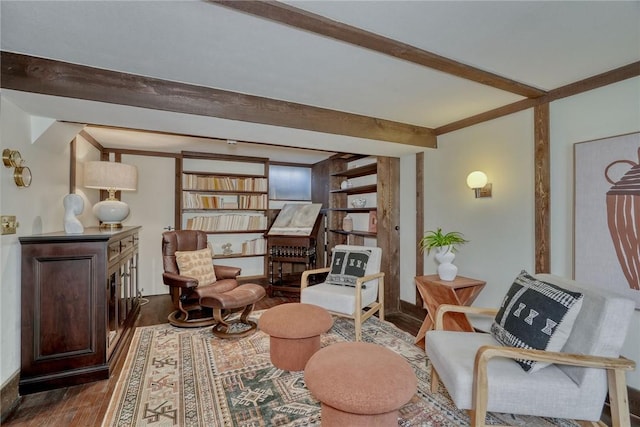 sitting room with beamed ceiling and wood finished floors