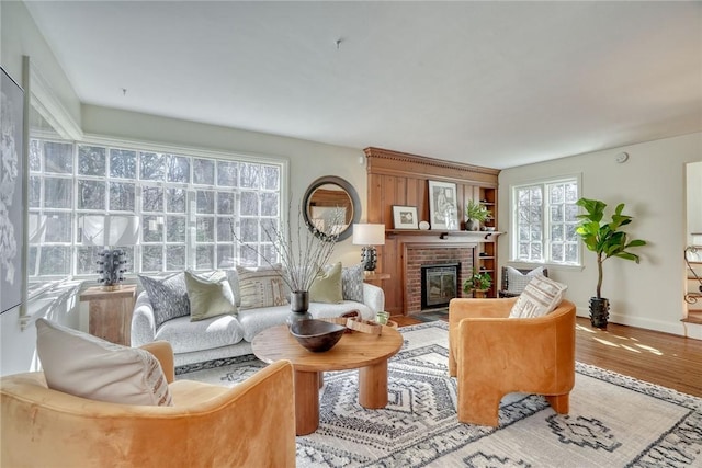 living room with wood finished floors, a fireplace, and baseboards