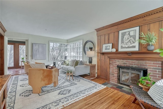 living area featuring a brick fireplace and wood finished floors