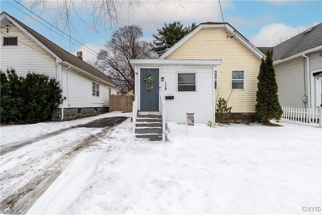 bungalow featuring entry steps and fence