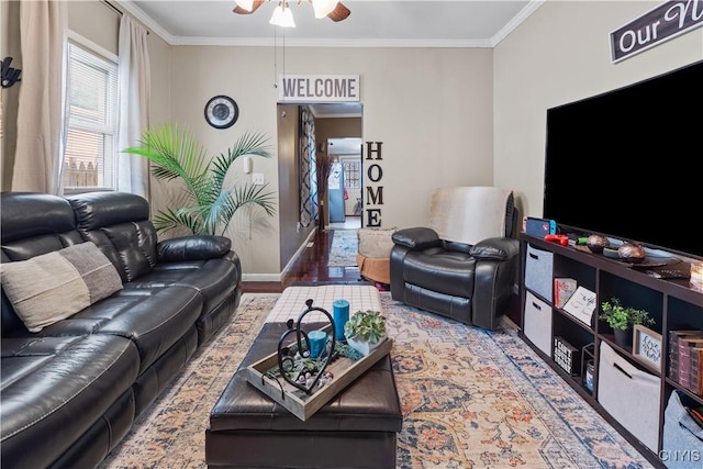 living room with a ceiling fan, crown molding, wood finished floors, and baseboards