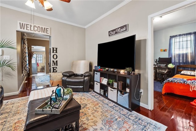 living room featuring ornamental molding, ceiling fan, baseboards, and wood finished floors