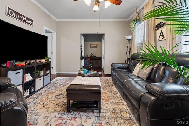 living room with wood finished floors, baseboards, ornamental molding, and a ceiling fan