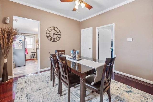 dining room featuring ceiling fan, baseboards, wood finished floors, and ornamental molding