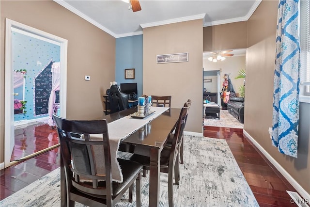 dining room featuring baseboards, a ceiling fan, wood finished floors, and crown molding