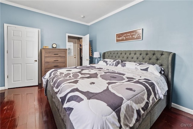 bedroom featuring baseboards, wood finished floors, and crown molding