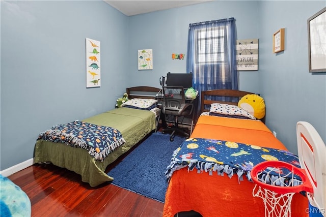 bedroom with baseboards and wood finished floors