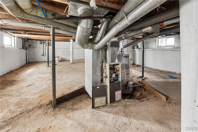 below grade area featuring heating unit, water heater, and a wealth of natural light