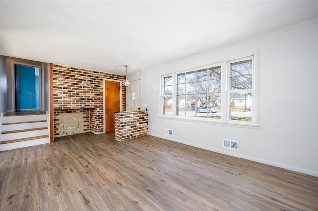 unfurnished room featuring visible vents, baseboards, and wood finished floors