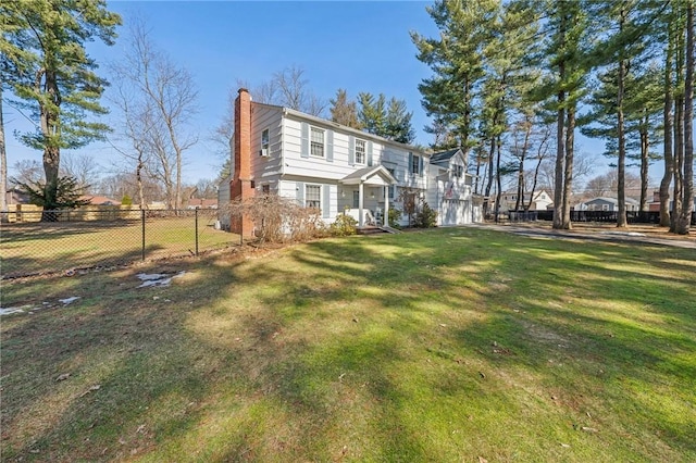 exterior space featuring a front yard, a chimney, and fence