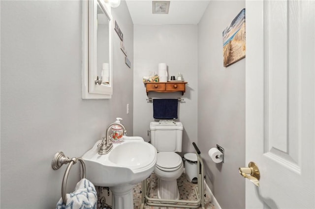 half bath featuring toilet and a sink