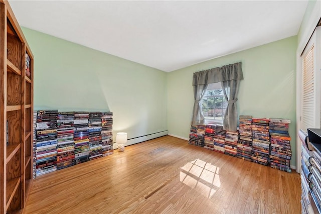 interior space with wood finished floors, baseboards, and a baseboard radiator