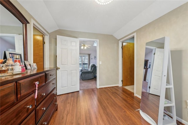 bedroom featuring vaulted ceiling, light wood-style floors, and baseboards