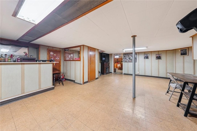 finished basement featuring tile patterned floors and a bar