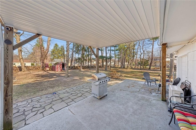 view of patio / terrace featuring an outbuilding, a shed, and a grill