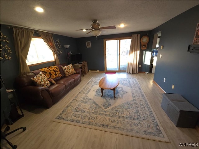 living room with plenty of natural light, a textured ceiling, ceiling fan, and wood finished floors