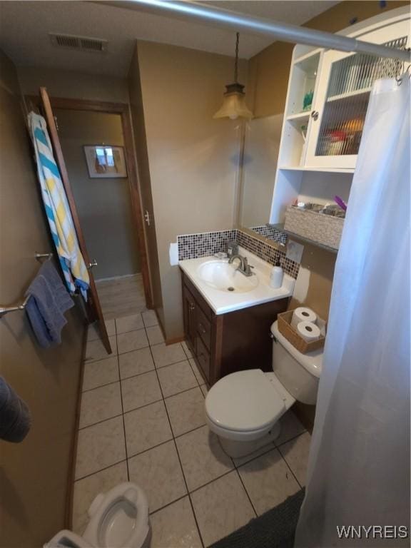 full bathroom featuring tile patterned flooring, visible vents, toilet, decorative backsplash, and vanity