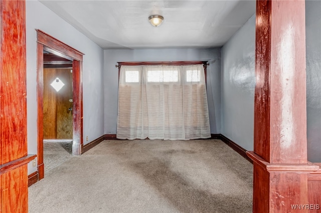 spare room featuring baseboards and carpet