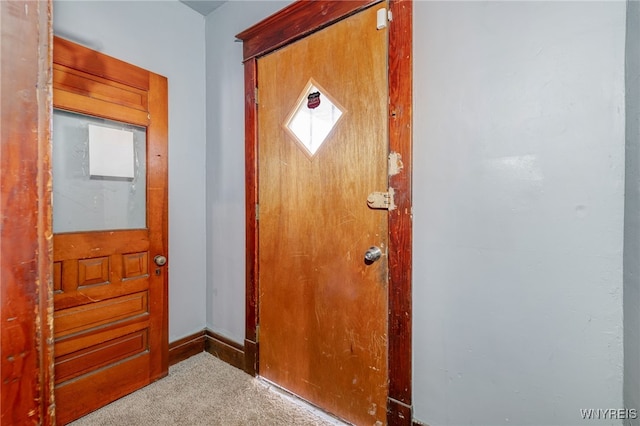 doorway to outside featuring carpet flooring and baseboards