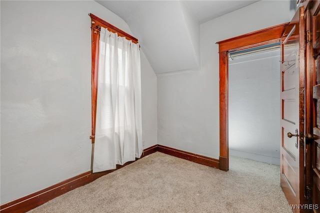 interior space featuring lofted ceiling, carpet, and baseboards