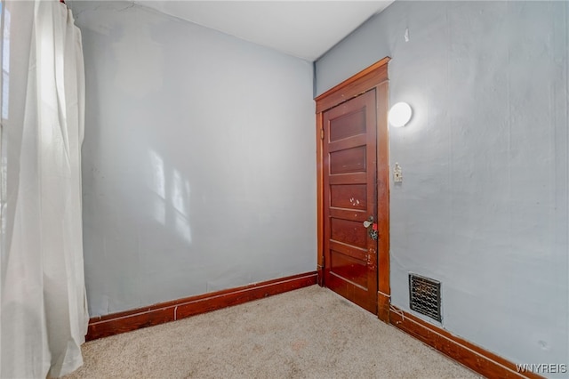 carpeted spare room with visible vents and baseboards