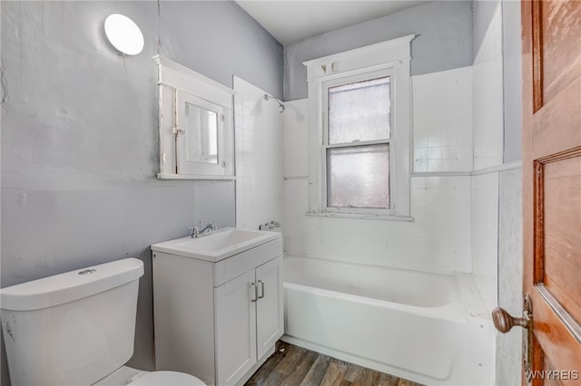 bathroom featuring bathing tub / shower combination, toilet, wood finished floors, and vanity