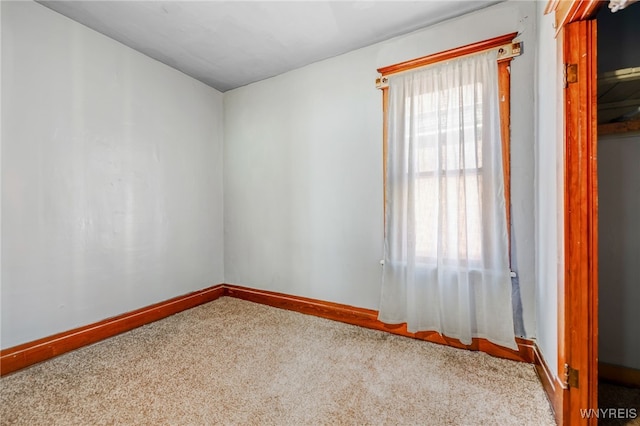 unfurnished room with baseboards and carpet floors