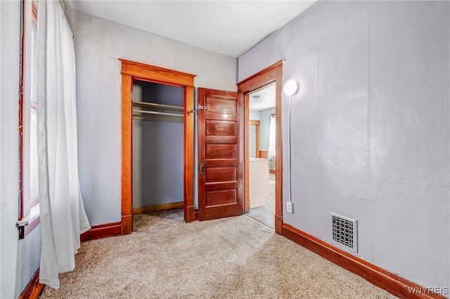 unfurnished bedroom with a closet, visible vents, and carpet floors