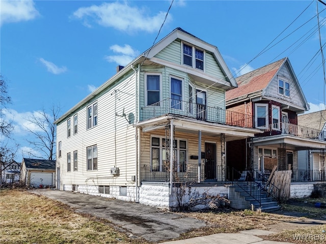 view of front of house with a balcony, covered porch, and driveway