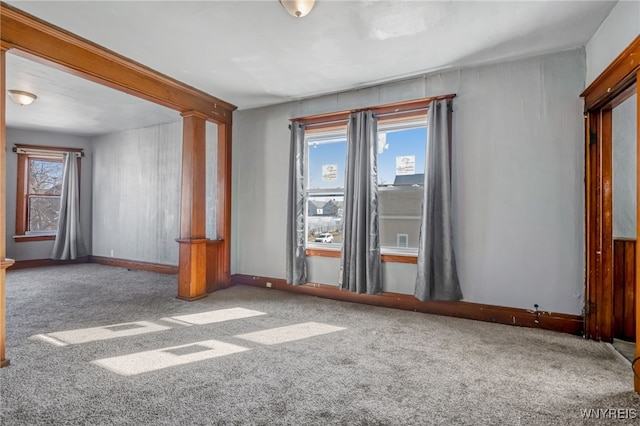 carpeted empty room featuring baseboards