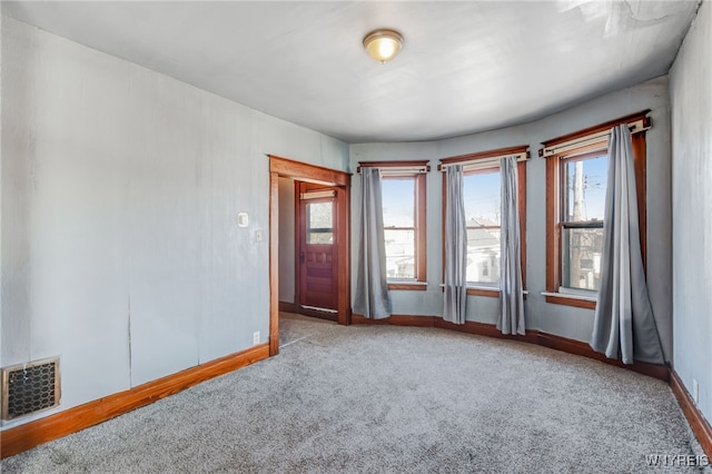 unfurnished room featuring carpet flooring, baseboards, visible vents, and plenty of natural light