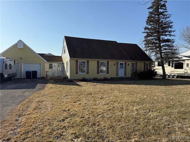 view of front facade with aphalt driveway, a garage, and a front lawn