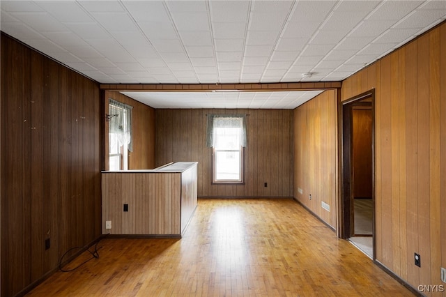 spare room with wooden walls and light wood finished floors