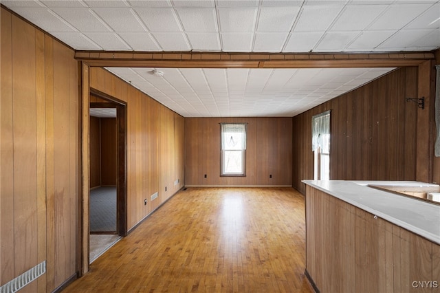 empty room with wooden walls and light wood finished floors