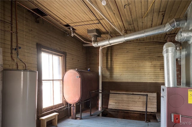 interior space with water heater, wooden walls, wooden ceiling, and heating fuel