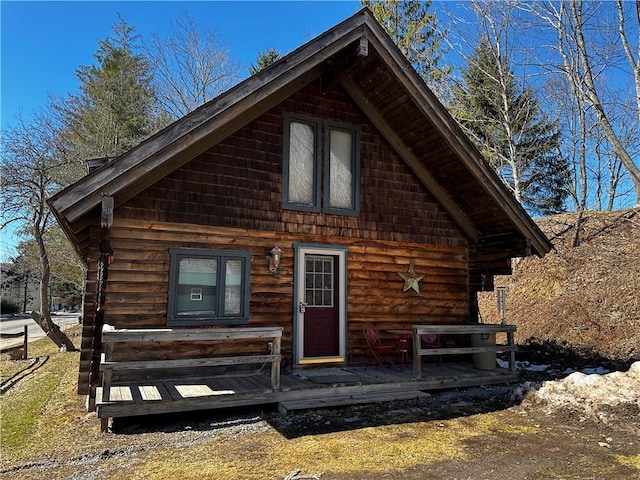 log-style house featuring log siding and a wooden deck