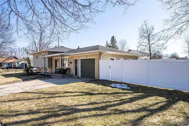 view of front of home with brick siding, fence, a front yard, a garage, and driveway