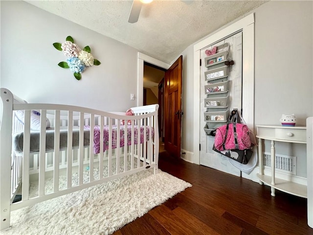 464 Pine St, Erwin, NY 14870 - bedroom with visible vents, a textured ceiling, wood finished floors, a nursery area, and ceiling fan