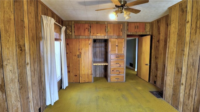 unfurnished bedroom with wood walls and light colored carpet