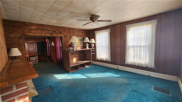 interior space featuring visible vents, carpet floors, and wood walls