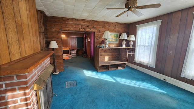 interior space with visible vents, wood walls, and a ceiling fan