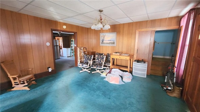 dining space with wooden walls, a paneled ceiling, and carpet floors