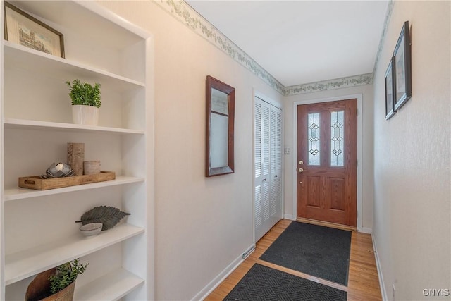 entrance foyer featuring baseboards and wood finished floors