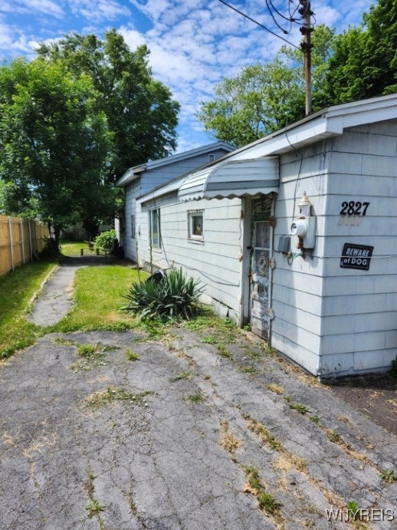 view of side of home with driveway and fence