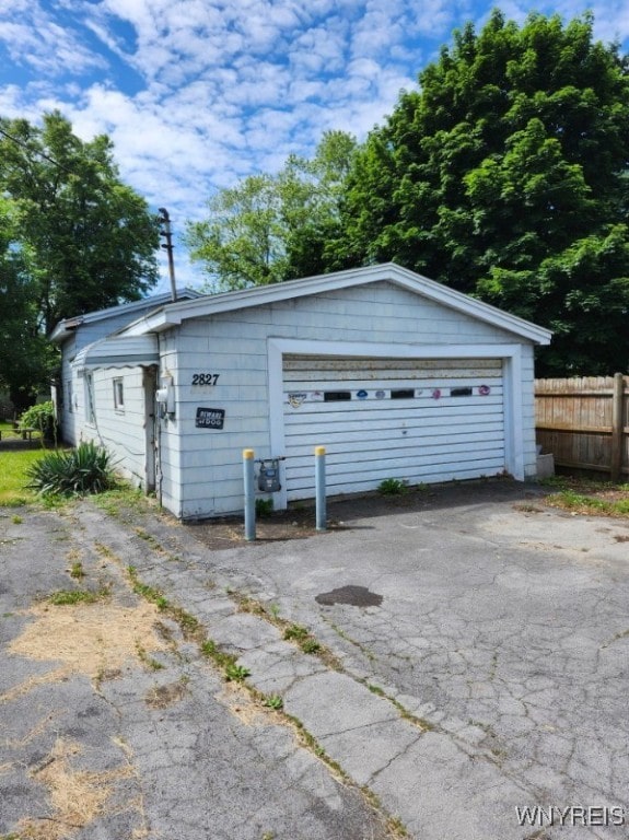 detached garage with driveway and fence