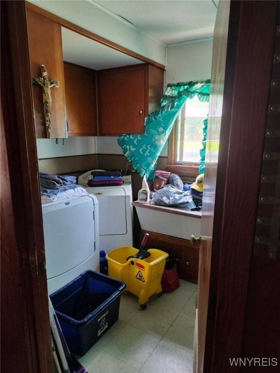 laundry room featuring tile patterned floors, cabinet space, and washing machine and clothes dryer