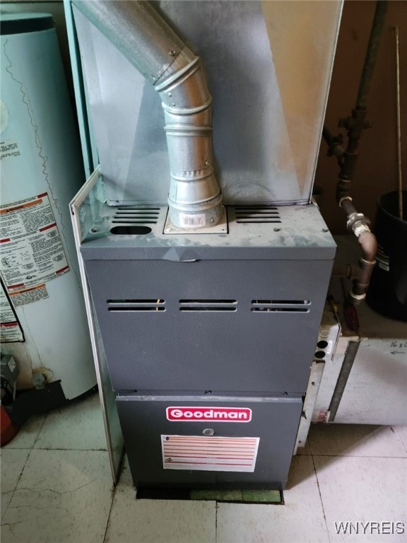 utility room featuring water heater and heating unit