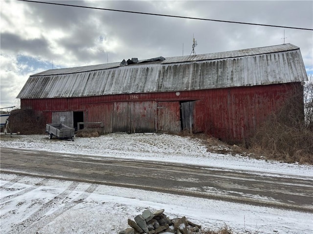 yard layered in snow with a barn and an outdoor structure