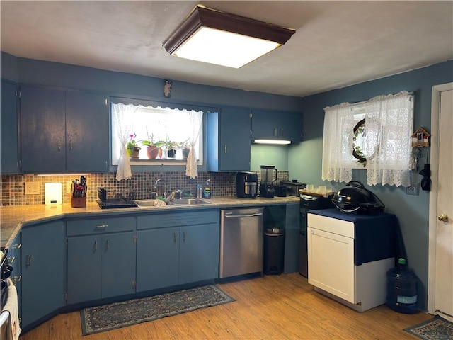 kitchen with dishwasher, decorative backsplash, light wood-style floors, blue cabinets, and a sink