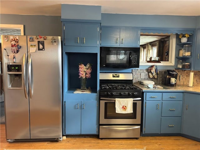 kitchen featuring blue cabinetry, light wood-style flooring, tasteful backsplash, and appliances with stainless steel finishes